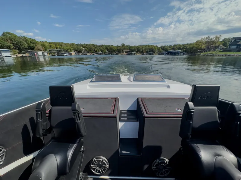 Slide: The Image of 2023 Cigarette 515 boat interior on a calm lake with scenic shoreline. - 16