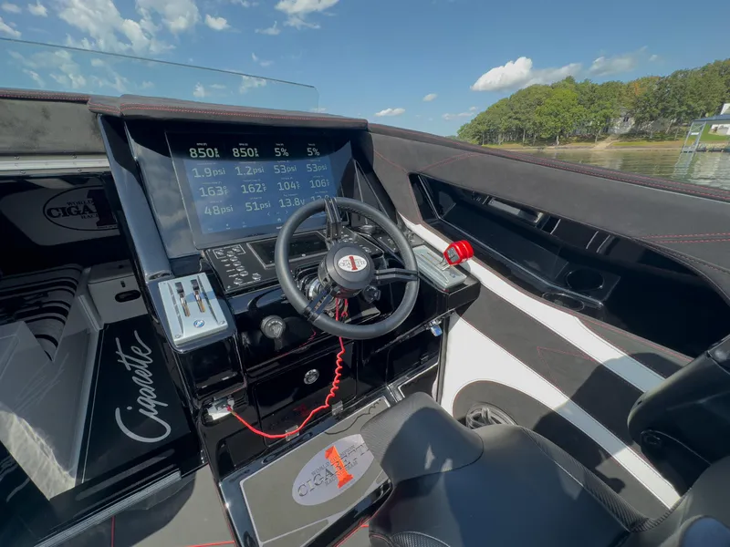 Slide: The Image of 2023 Cigarette 515 boat cockpit with advanced controls and digital displays, under a clear blue sky. - 22