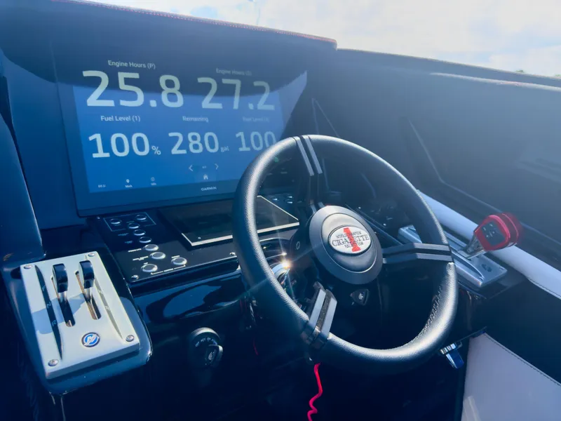 Slide: The Image of 2023 Cigarette 515 boat dashboard with steering wheel and digital display showing engine hours and fuel level. - 32