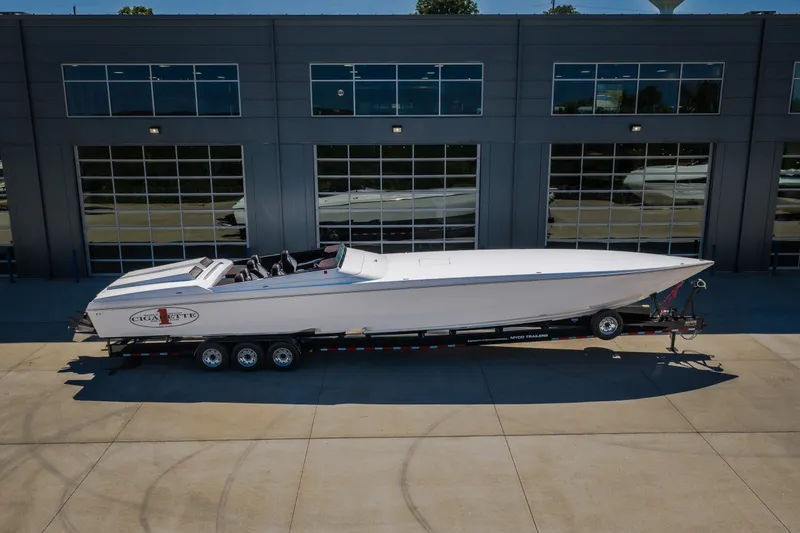 Slide: The Image of 2023 Cigarette 515 boat on trailer, parked outside a modern building. - 15