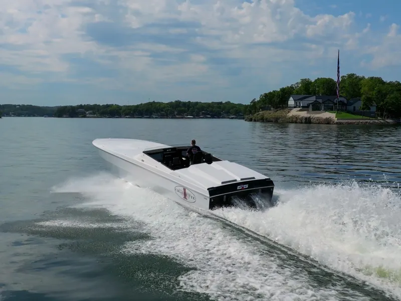 Slide: The Image of 2023 Cigarette 515 speedboat cruising on a lake with scenic shoreline. - 4