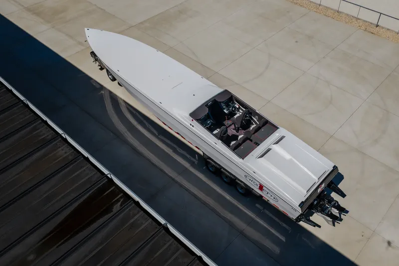 Slide: The Image of 2023 Cigarette 515 powerboat on trailer, aerial view, sleek design, parked on concrete surface. - 17