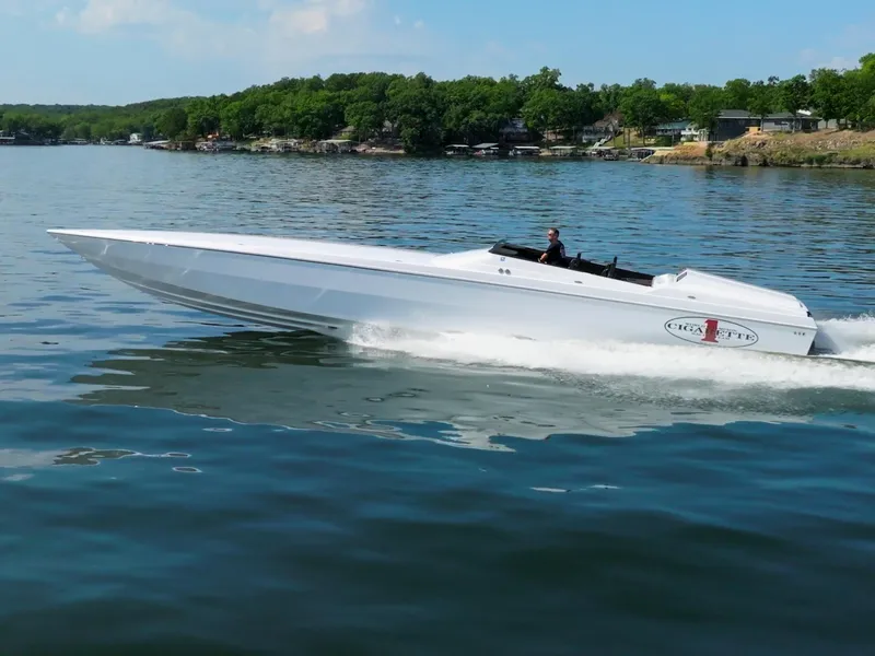 Slide: The Image of 2023 Cigarette 515 speedboat cruising on a lake with scenic shoreline background. - 5