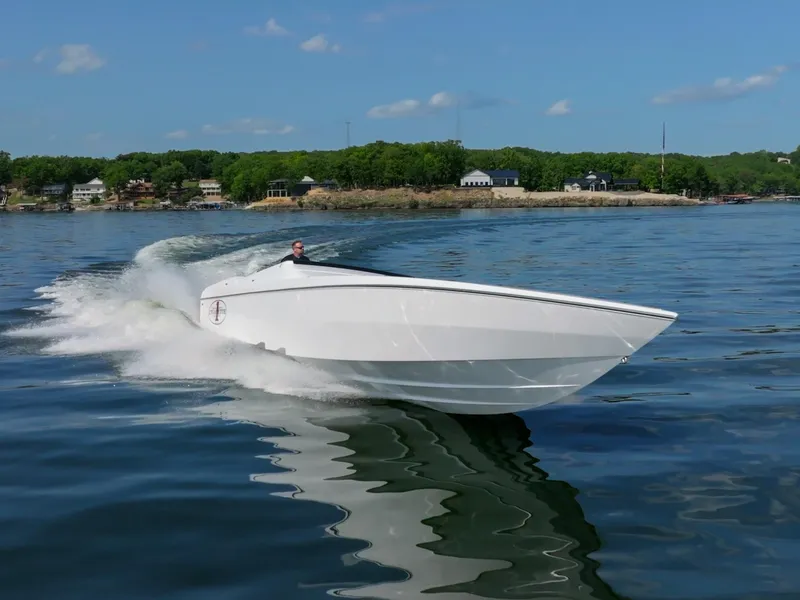Slide: The Image of 2023 Cigarette 515 speedboat cruising on a calm lake under a clear blue sky. - 6