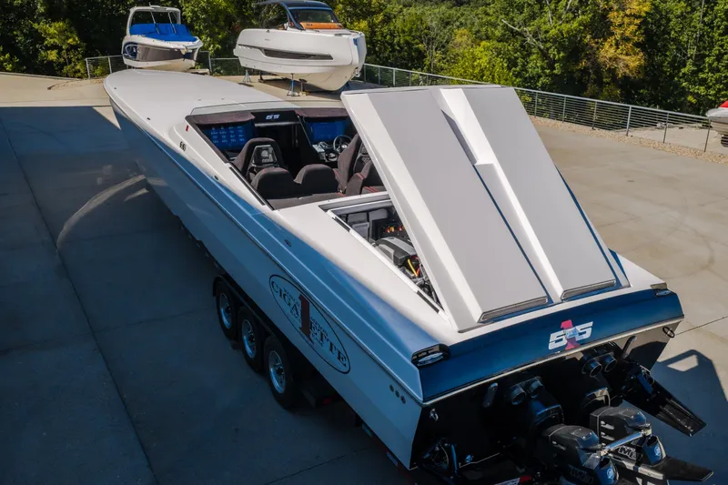 Slide: The Image of 2023 Cigarette 515 powerboat with open engine hatch, parked on concrete surface. - 67