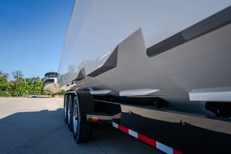 Slide: The Image of 2023 Cigarette 515 boat on trailer, showcasing sleek hull design under clear blue sky. - 10