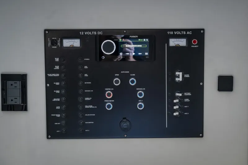Slide: The Image of Control panel of a 2023 Cigarette 515 boat, featuring 12V DC and 110V AC systems. - 75