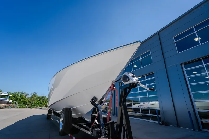 Slide: The Image of 2023 Cigarette 515 boat on trailer outside modern building under clear blue sky. - 5