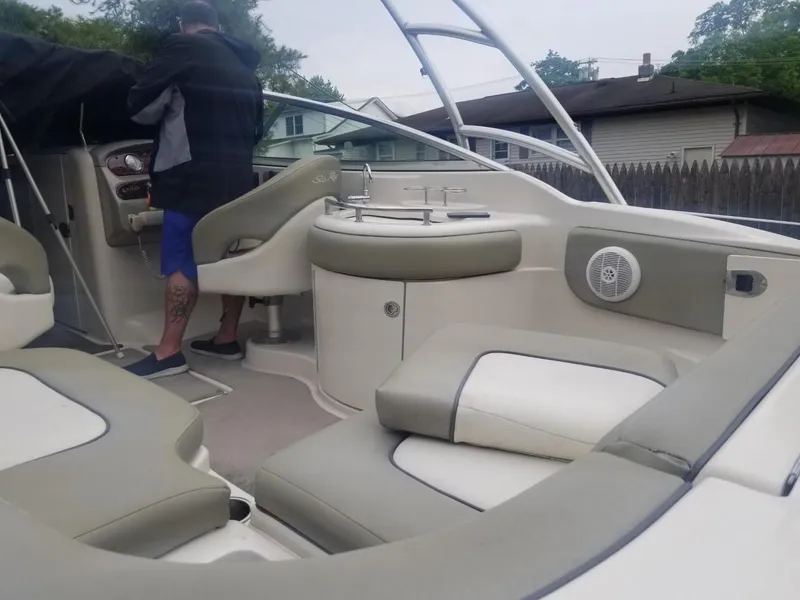 Slide: The Image of 2006 Sea Ray 270 Sundeck interior with seating and helm, featuring a person standing. - 11