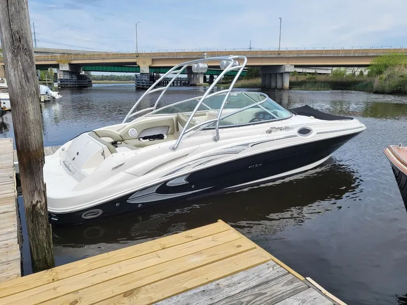 Slide: The Image of 2006 Sea Ray 270 Sundeck boat docked on calm water near a bridge. - 45