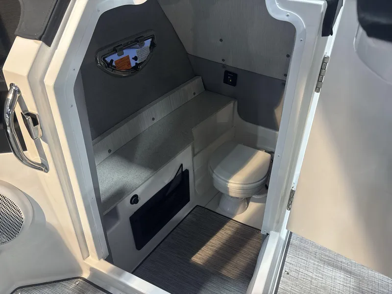 Slide: The Image of 2025 Cobalt R8 Surf boat interior with compact bathroom and modern amenities. - 12