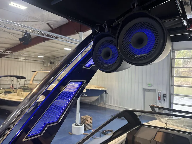 Slide: The Image of 2025 Cobalt R8 Surf boat with blue LED speakers in a showroom. - 13
