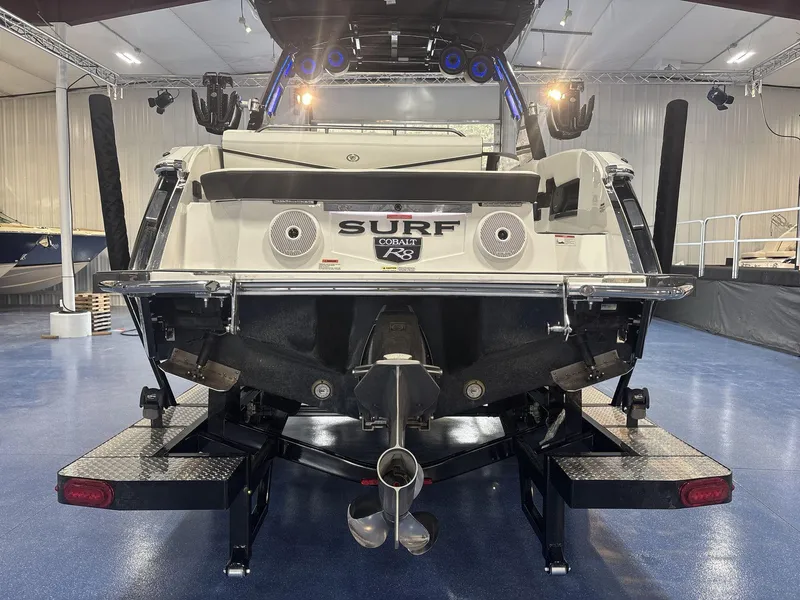 Slide: The Image of 2025 Cobalt R8 Surf boat rear view in showroom setting. - 5