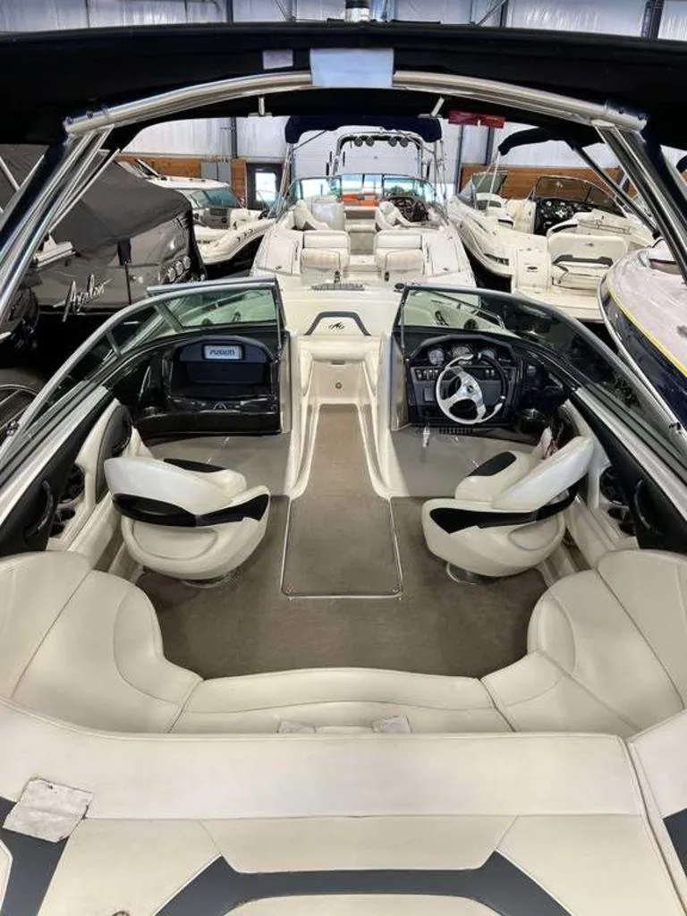 Slide: The Image of Interior view of a 2014 Monterey 224FSX boat with seating and steering wheel. - 2
