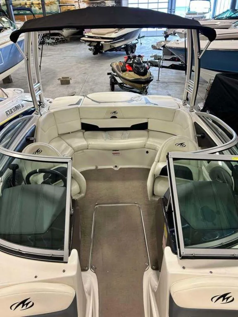 Slide: The Image of 2014 Monterey 224FSX boat interior with seating and steering wheel in a showroom. - 6