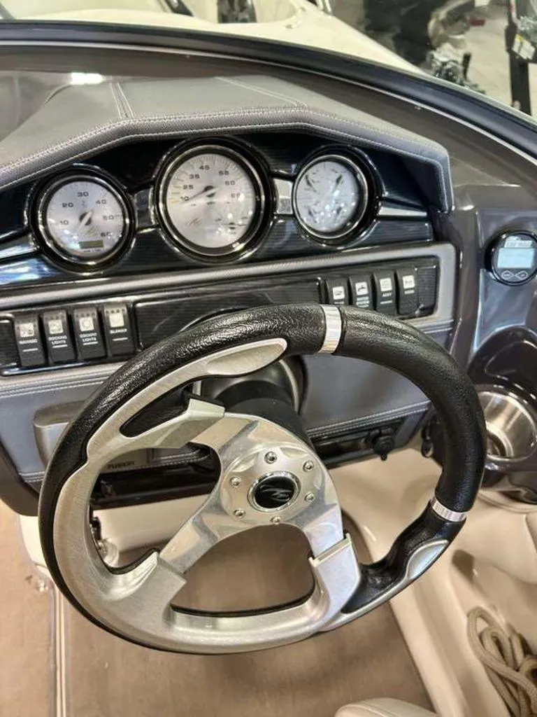 Slide: The Image of Steering wheel and dashboard of a 2014 Monterey 224FSX boat, featuring gauges and controls. - 7