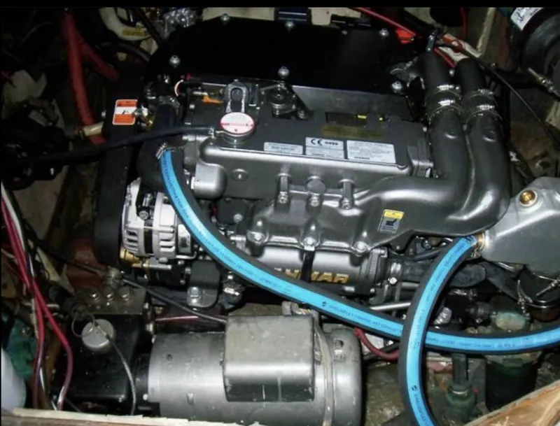 Slide: The Image of Engine of 1980 Wellington 44 Cutter Center Cockpit with visible blue hoses and components. - 13