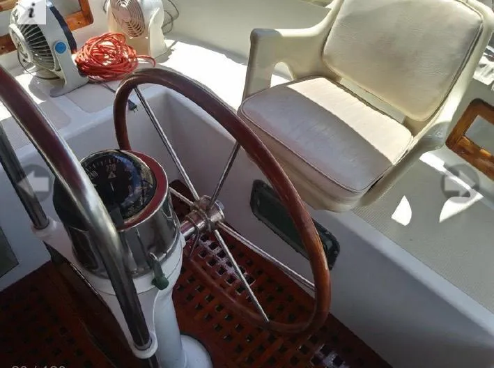 Slide: The Image of Cockpit of 1980 Wellington 44 Cutter Center with wooden steering wheel and cushioned seat. - 3