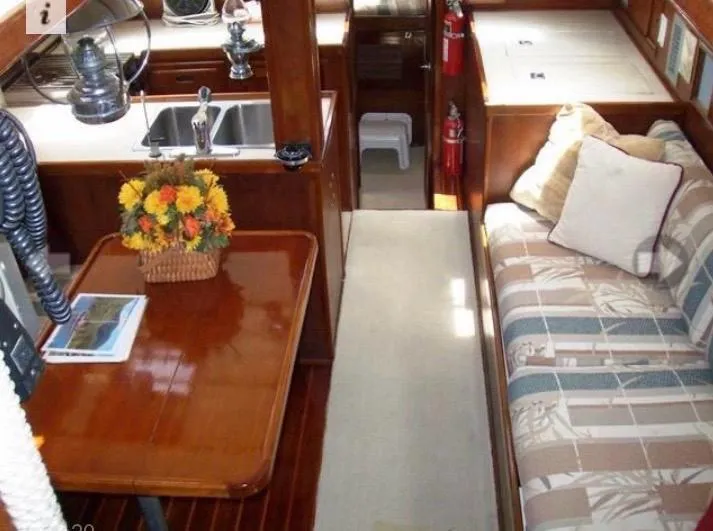 Slide: The Image of Interior of 1980 Wellington 44 Cutter Center Cockpit with cozy seating and wooden table. - 5