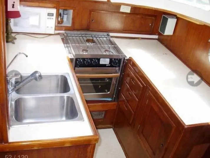 Slide: The Image of 1980 Wellington 44 Cutter Center Cockpit kitchen with dual sinks and stove. - 7