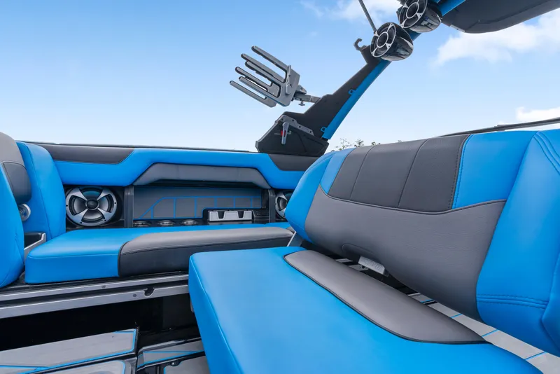 Slide: The Image of 2021 Malibu Wakesetter 25 LSV interior with blue and gray seating, speakers, and wakeboard rack. - 14