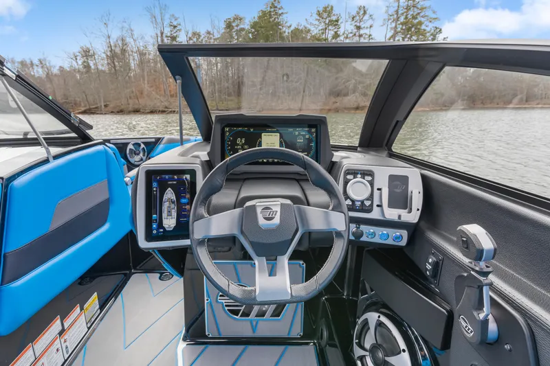 Slide: The Image of 2021 Malibu Wakesetter 25 LSV dashboard with modern controls and steering wheel on a lake. - 25