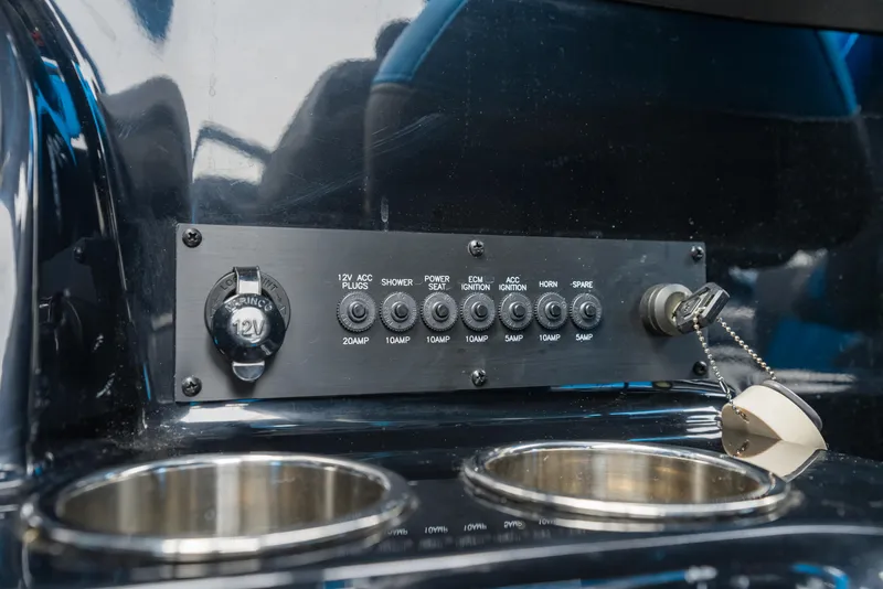 Slide: The Image of Control panel and cup holders in 2021 Malibu Wakesetter 25 LSV boat interior. - 26