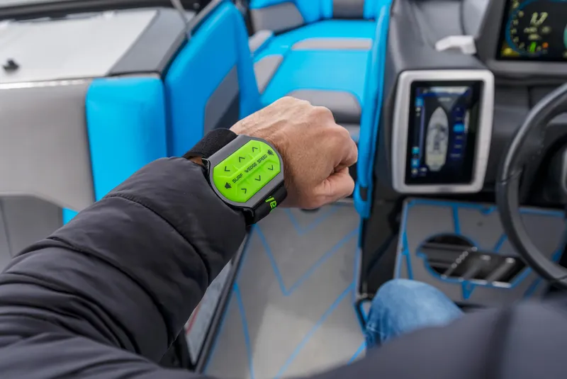 Slide: The Image of Man wearing a green wrist controller inside a 2021 Malibu Wakesetter 25 LSV boat. - 27