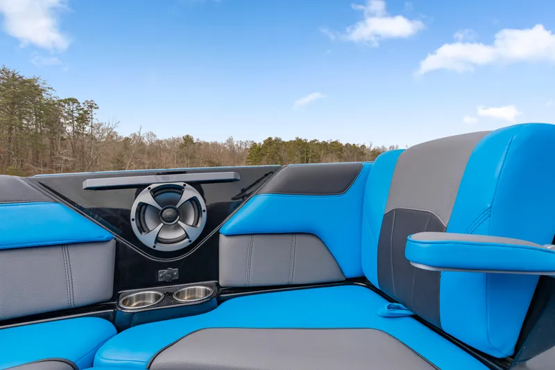 Slide: The Image of 2021 Malibu Wakesetter 25 LSV interior with blue and gray seating, speaker, and cup holders. - 6