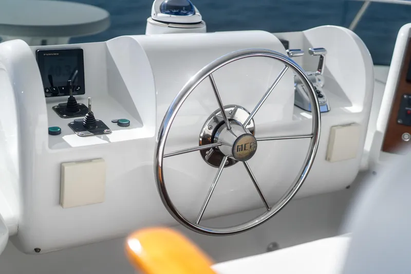 Slide: The Image of Steering wheel of 2007 MCP Tri-Deck yacht, featuring control panels and navigational instruments. - 9