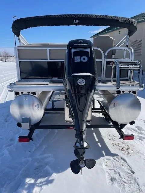 Slide: The Image of 2025 Sun Tracker Party Barge 16 DLX pontoon boat with Mercury 50 engine, rear view in snow. - 3