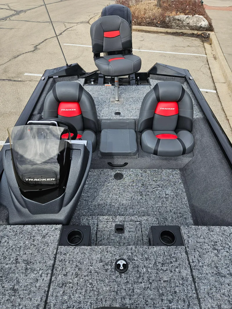 Slide: The Image of 2025 Tracker Pro Team 175 boat with gray and red seating, parked on pavement. - 2