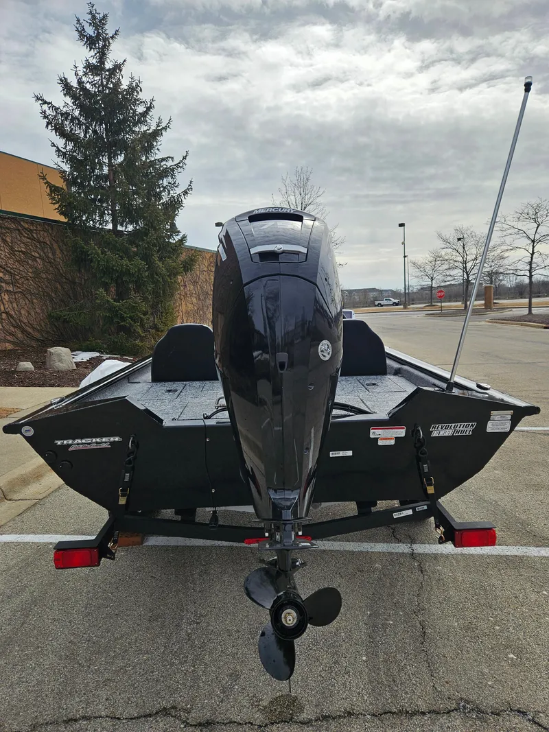 Slide: The Image of 2025 Tracker Pro Team 175 boat, rear view, parked outdoors on a cloudy day. - 5