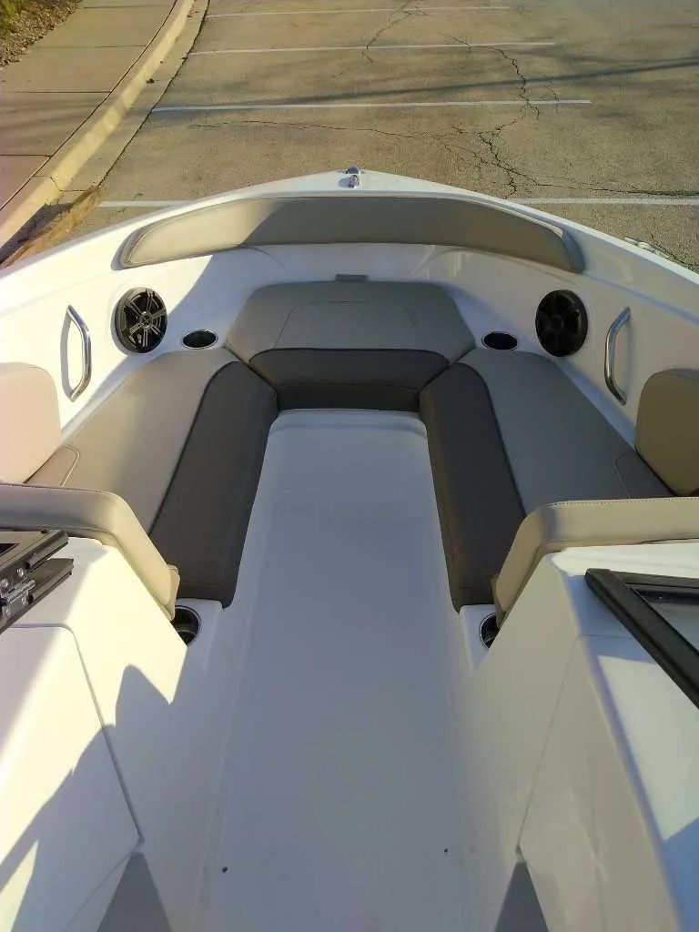 Slide: The Image of 2025 Tahoe 210 S boat interior with cushioned seating and speakers. - 2