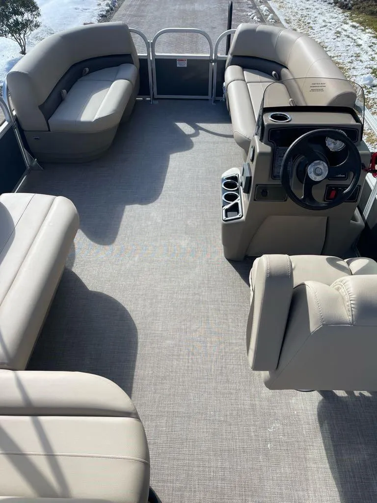 Slide: The Image of 2025 Sun Tracker Party Barge 16 DLX interior with spacious seating and steering console. - 4