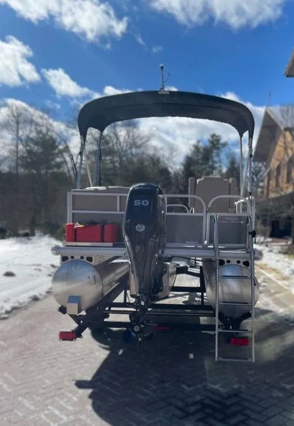 Slide: The Image of 2025 Sun Tracker Party Barge 16 DLX pontoon boat on a snowy driveway. - 7