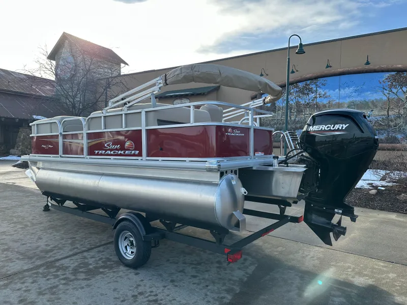 Slide: The Image of 2025 Sun Tracker Party Barge 18 DLX pontoon boat with Mercury engine on trailer. - 2