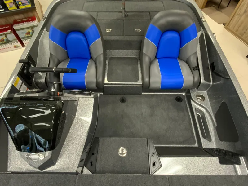 Slide: The Image of 2025 Ranger Z185 boat interior with dual blue and gray seats, steering console, and storage compartments. - 11