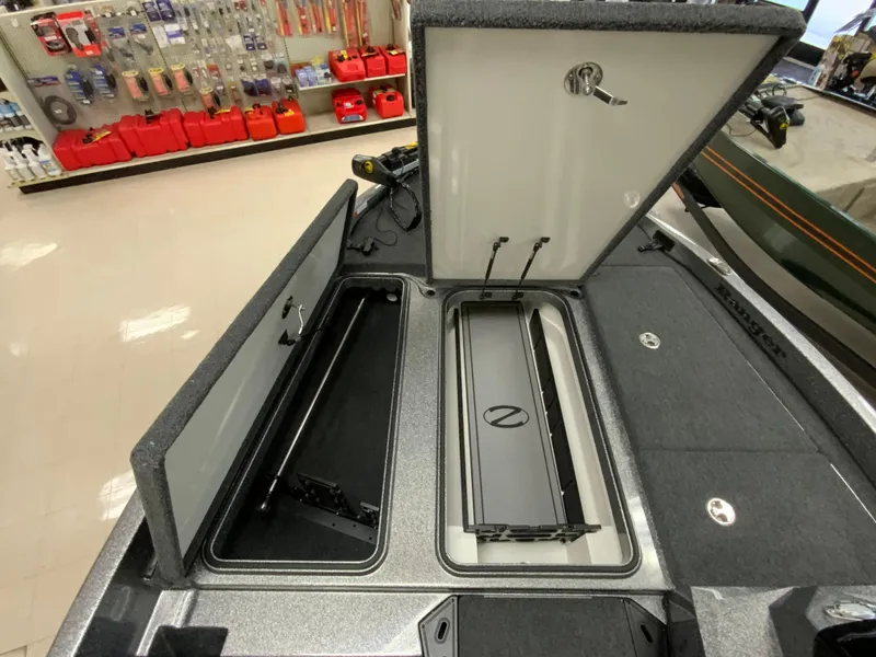 Slide: The Image of 2025 Ranger Z185 boat storage compartments open in a showroom, showcasing interior features. - 12