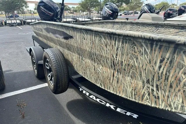 Slide: The Image of 2025 Tracker Grizzly 1650 T Prairie Wings Edition boat with camouflage design in parking lot. - 5