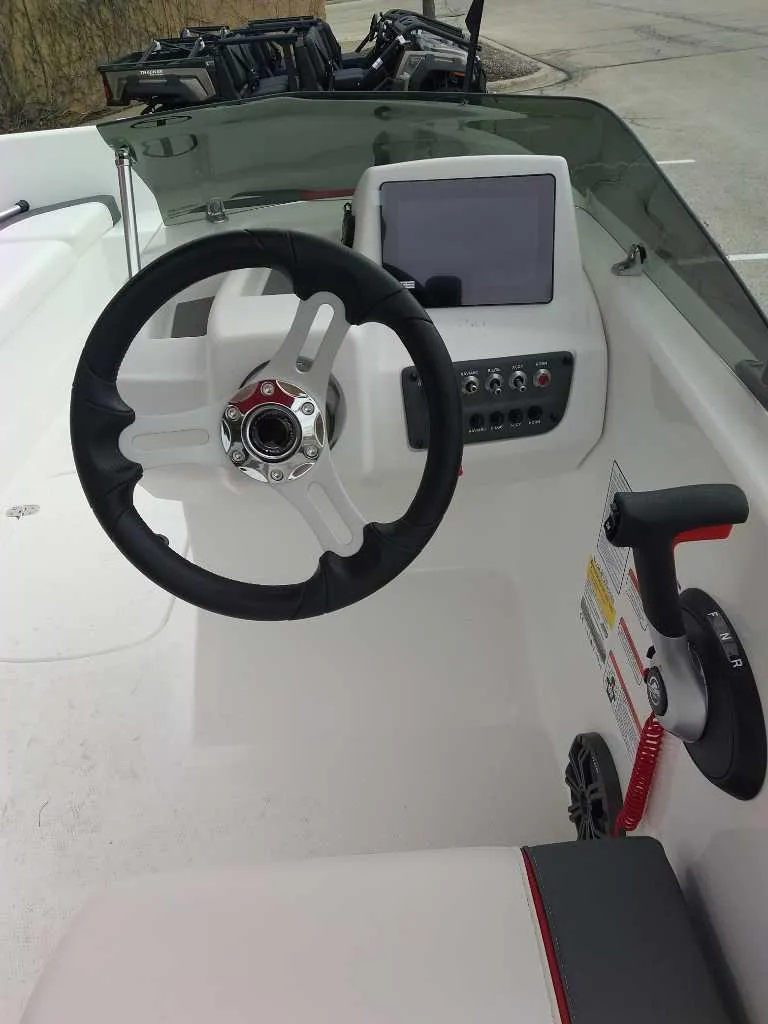 Slide: The Image of 2025 Tahoe T16 boat dashboard with steering wheel and control panel. - 2