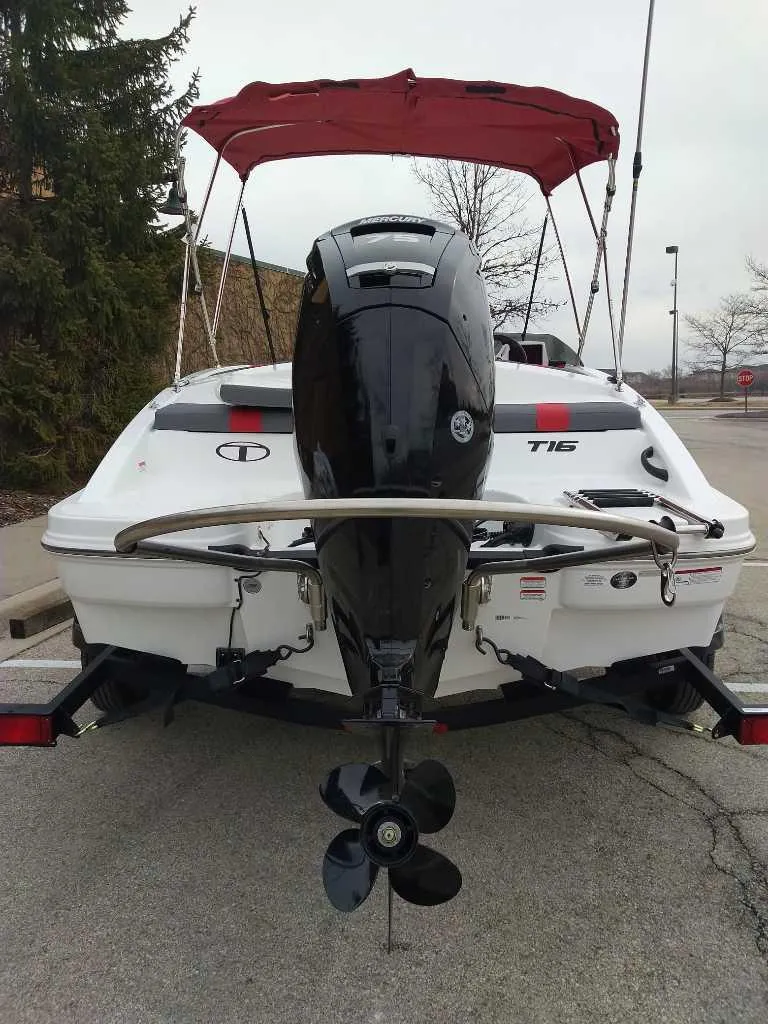 Slide: The Image of 2025 Tahoe T16 boat with outboard motor and red canopy, parked on a trailer. - 4