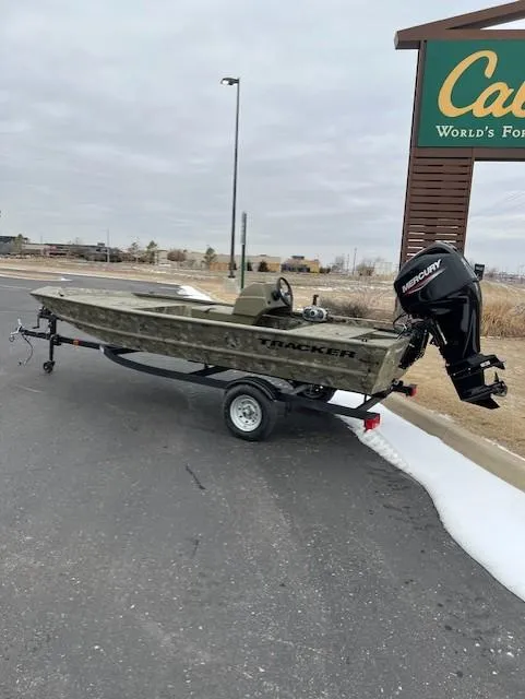 Slide: The Image of 2025 Tracker Grizzly 1648 SC boat on trailer, parked near Cabela's sign. - 3