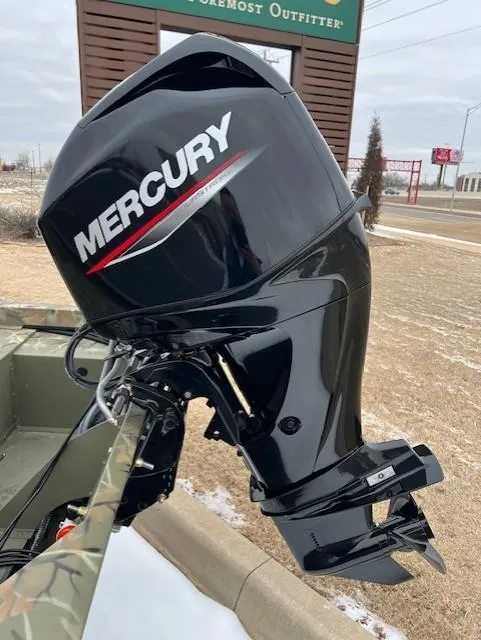 Slide: The Image of 2025 Tracker Grizzly 1648 SC with Mercury outboard motor, parked outdoors. - 6