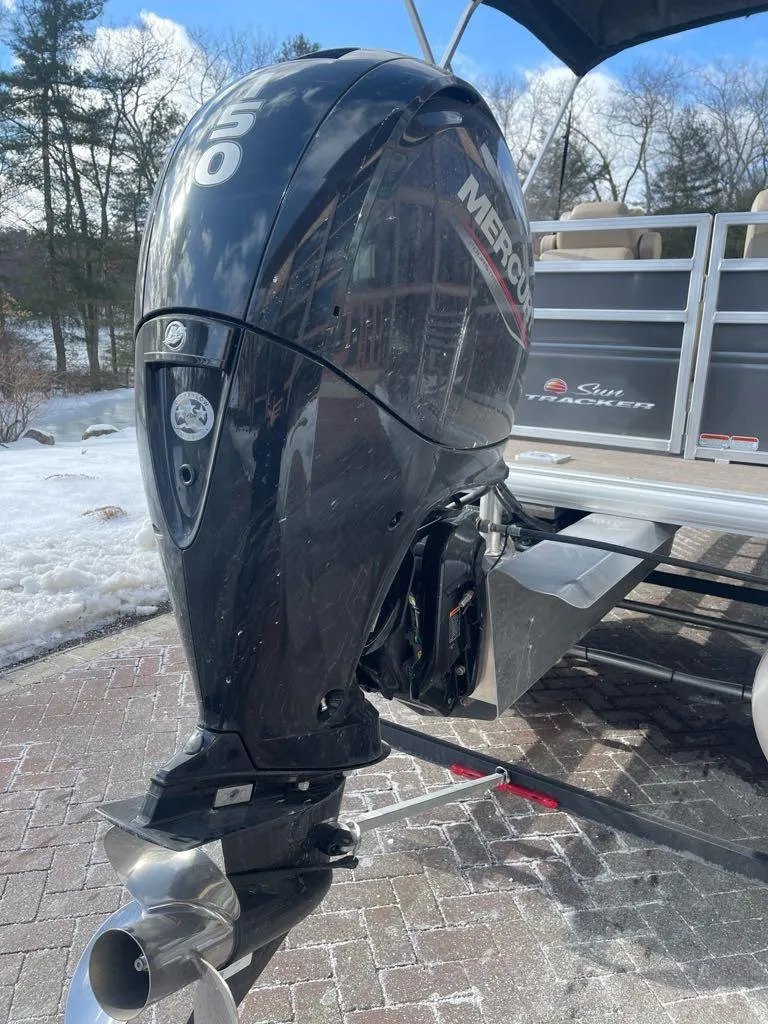 Slide: The Image of 2025 Sun Tracker Party Barge 22 DLX with Mercury outboard motor on snowy driveway. - 4