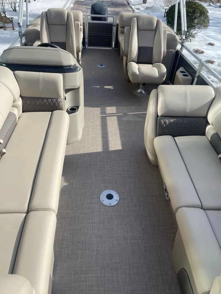 Slide: The Image of 2025 Sun Tracker Party Barge 22 DLX interior with beige seating and spacious layout. - 6