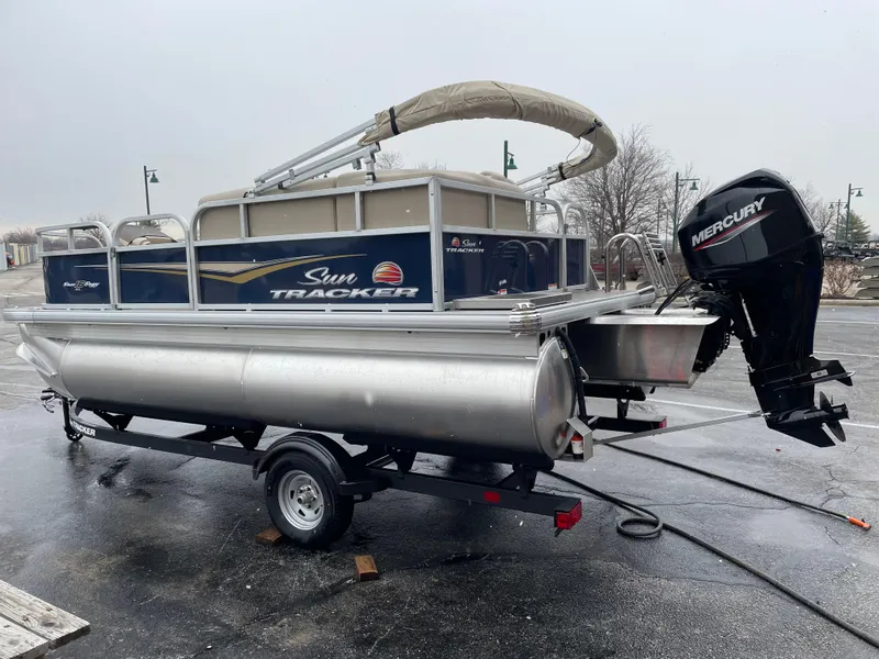 Slide: The Image of 2025 Sun Tracker Bass Buggy 16 XL Select pontoon boat with Mercury outboard motor. - 2