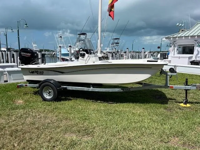 The Image of 2025 Mako Pro Skiff 15 CC boat on trailer at marina, cloudy sky background. - 0