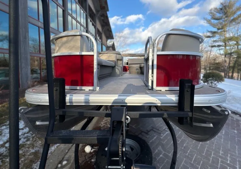 Slide: The Image of 2025 Sun Tracker Party Barge 18 DLX pontoon boat on trailer, outdoor setting. - 3