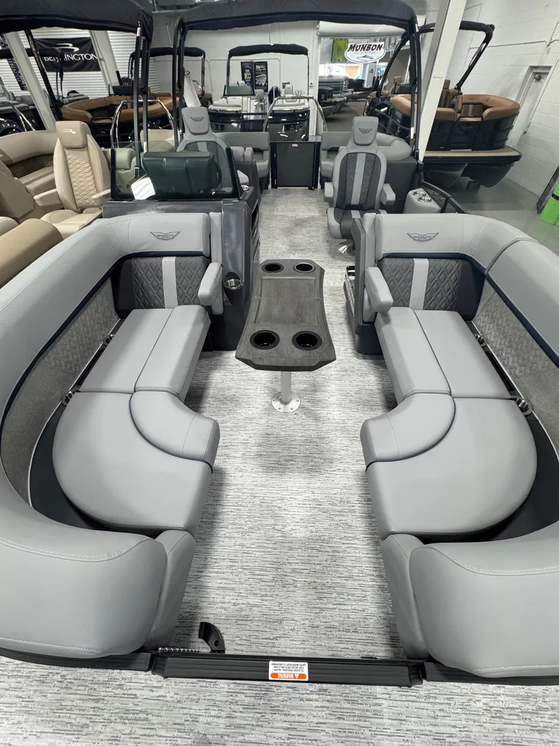 Slide: The Image of 2025 Bennington M Quad Bench 22 MFB pontoon boat interior with gray seating and central table. - 11